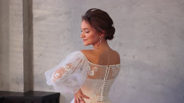 Charming Young Girl in a White Dress Posing Beautifully with Her Back