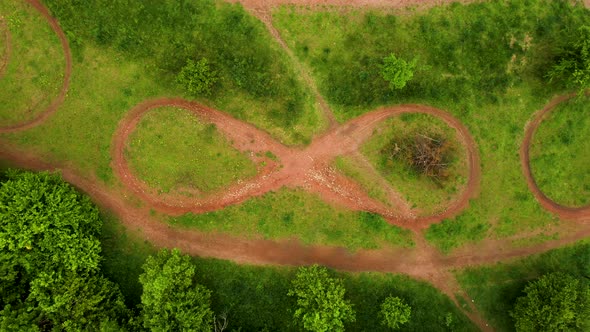 Aerial Shot of Infinity Sign Moto Bike Dirt Track With Grass and Trees Around