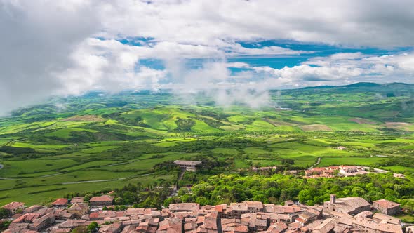 Time lapse aerial: unique green landscape in Orcia Valley, Tuscany, Italy. Scenic clouds moving by w