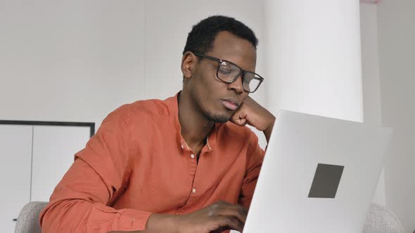 AfricanAmerican Man Falls Asleep Near Laptop at Table