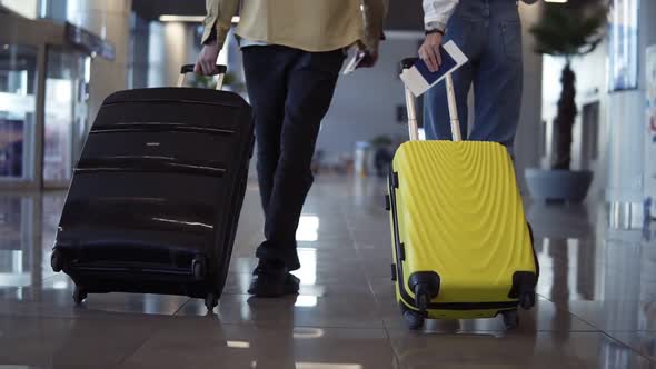 Pair of Travelers are Carrying Their Luggage and Passports