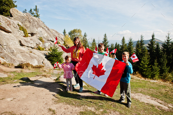 hold large Canadian flag celebration in mountains.