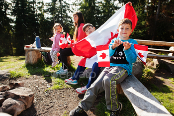 hold large Canadian flag celebration in mountains.