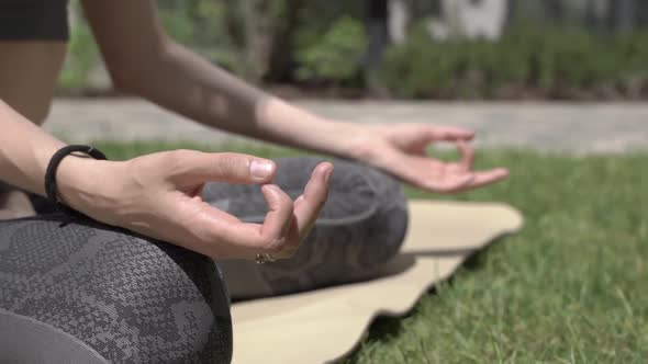 Woman Practices Meditation Yoga Outdoors in the Lotus Position in Sunny Summer Weather