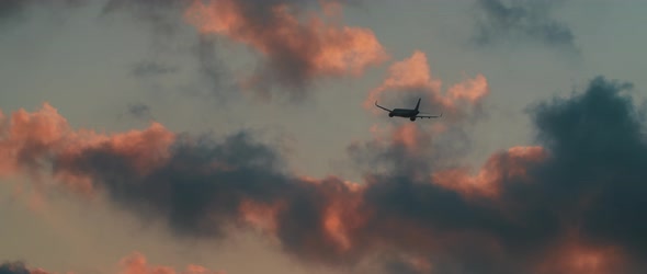 Plane flying in the clouds at sunset, cinematic slow motion, BMPCC 4K