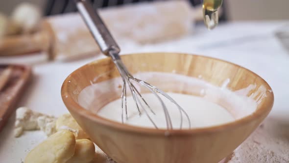 Hand stirring pouring and eggs to cups for flour on the table with for making various desserts