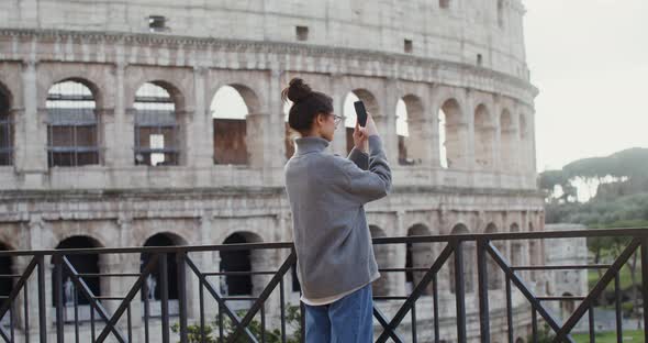 A Woman Takes Photographs of Sights of Rome on a Mobile Phone Near the Coliseum