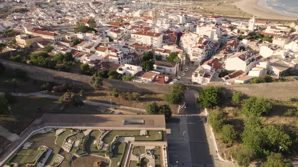 Aerial depicting the historic wall surrounding the coastal city of Lagos in Portugal