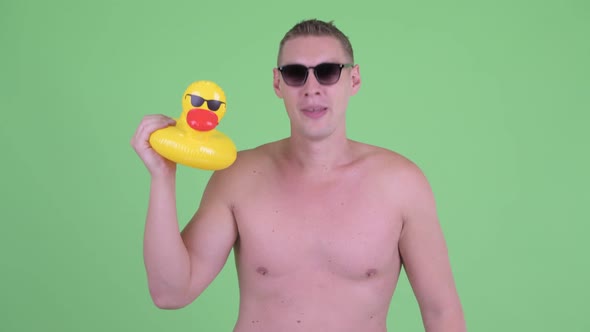 Happy Shirtless Young Man with Rubber Duck Ready To Party