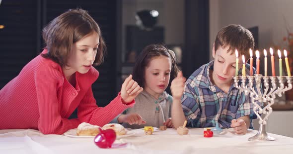 Kids playing with dreidels during Hanukka at home