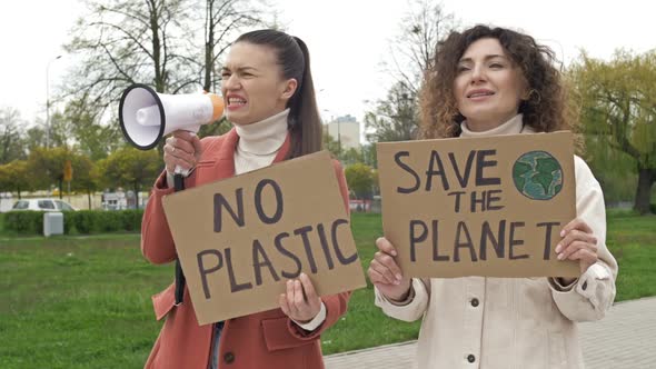 Two Women are Standing with Posters SAVE THE PLANET and NO PLASTIC