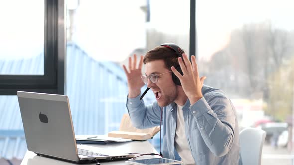 Excited Businessman Celebrating Success on Video Call at Remote Workplace