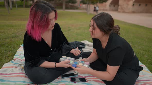 Young Girls Holding a Makeup Color Palette Discussing Which to Choose