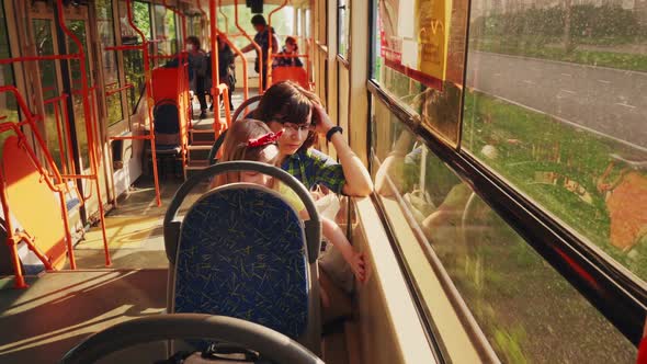 Mother and Happy Daughter Ride in the Tram and Look Out the Window