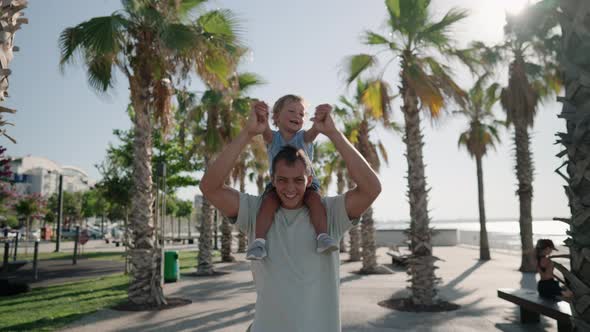 Father Carrying Son 1217 Months on Shoulders and Walking Around at Beach