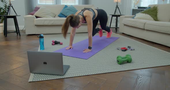 Sportswoman Doing Morning Fitness Exercises with Help of Her Instructor Online on Laptop. Healthy