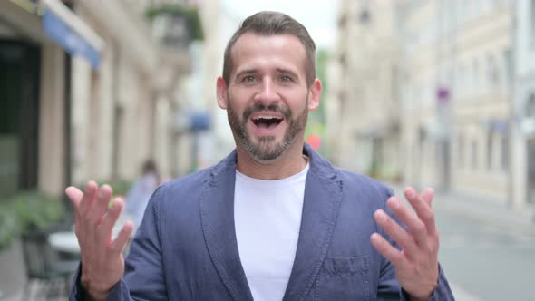 Outdoor Portrait of Excited Man Celebrating Success