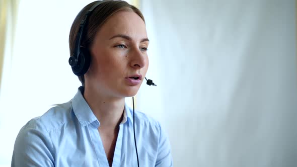 Customer Support Agent or Call Center with Headset Works on Desktop Computer While Supporting 