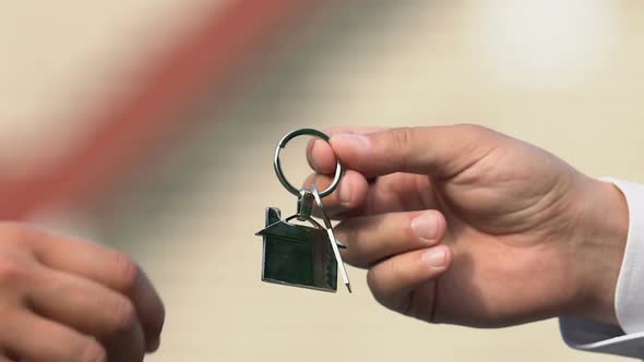 Male Hand Taking House Key From Real Estate Agent