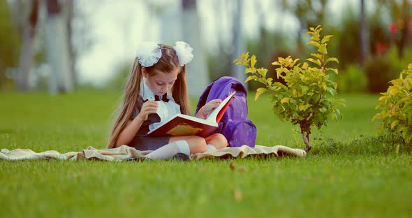 Cute Child Girl Reading Book in Summer Garden Outdoor