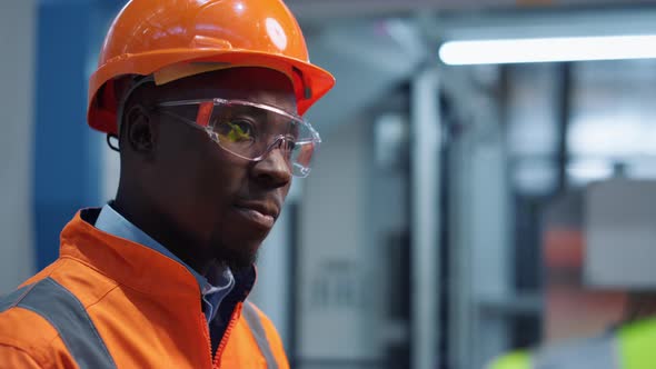 Man Engineer Shaking Head Wearing Safety Uniform at Modern Factory Closeup