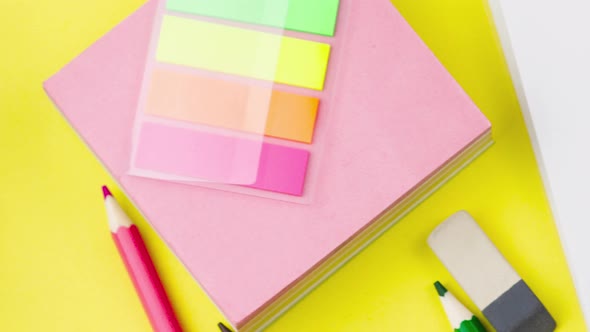 Various School Supplies Lie on a Pastel Yellow Background