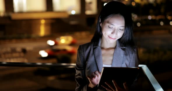 Business woman using tablet computer at night 