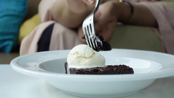 Women Eating Slice of Brownie on Plate on Table