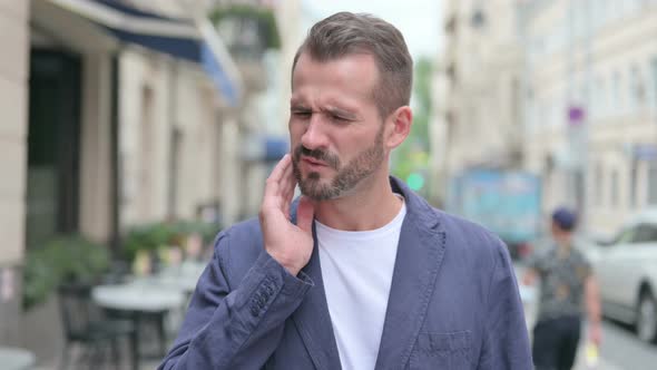 Outdoor Portrait of Man Having Toothache Cavity