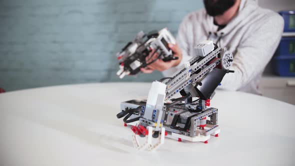 assembling a model of robotics from plastic toy blocks