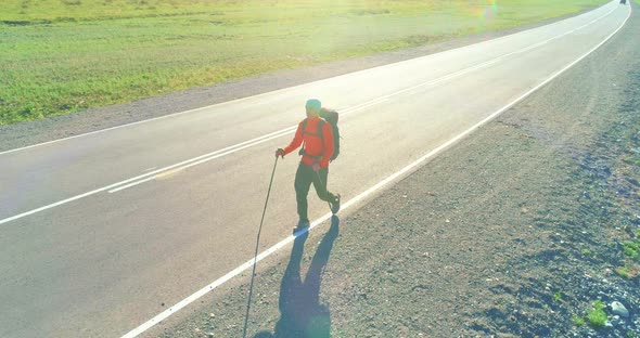 Flight Over Hitchhiker Tourist Walking on Asphalt Road