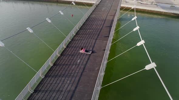 Aerial view of woman doing exercise in bridge on Abu Dhabi, U.A.E