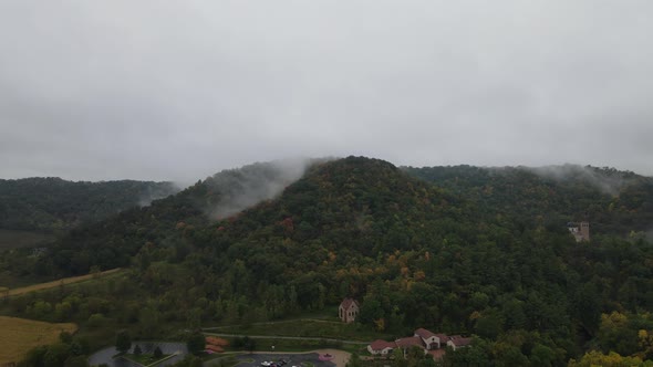 Fog lifting out of valley and off bluffs in autumn. Prayer chapel nestled into the trees.