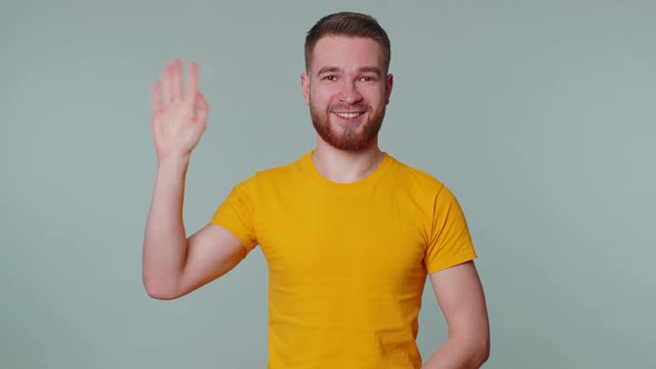 Bearded Man Smiling Friendly at Camera and Waving Hands Gesturing Hello or Goodbye Welcoming