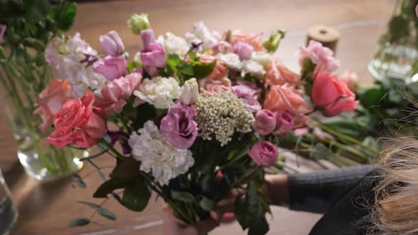 Florist Woman Arranges Fresh Spring Bouquet in Flowershop