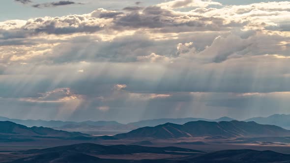 Beams of light shining through the clouds moving through the sky