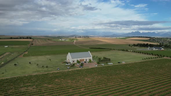 white farmhouse in green vineyard valley of Franschoek South Africa, aerial