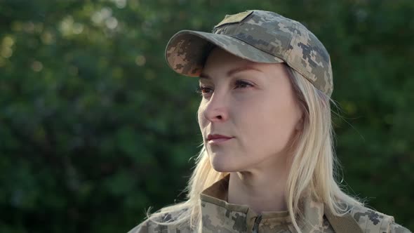 Portrait of Female Soldier in Camouflage Uniform Looking Away Close Up