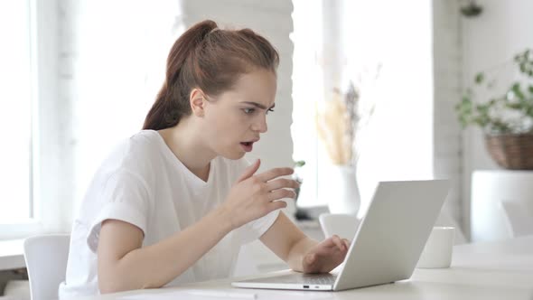 Shocked Young Woman wondering while Working on Laptop