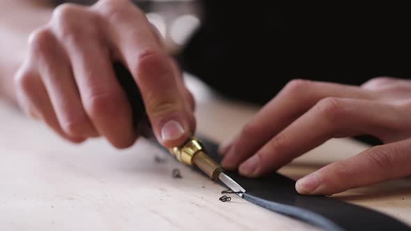 The Leather Craftsman Is Cutting the Edges of a Belt