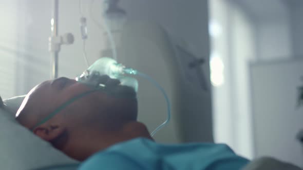 Recovering Patient with Oxygen Mask Lying in Bed Emergency Unit Ward Closeup