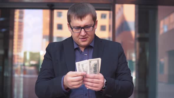 Businessman Counting Money Standing Near Business Center