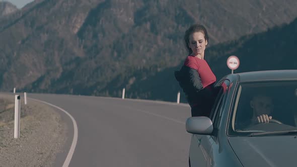 Happy Brunette Travels Sitting on Vintage Car Window