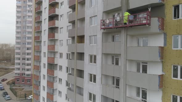 Builders in facade lift Insulation and plastering of multi-storey apartment building 10