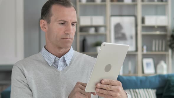 Middle Aged Man Browsing on Tablet