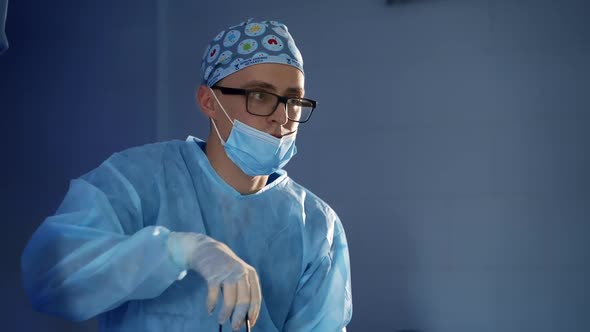 Surgeon During Operation. Portrait of male surgeon doctor wearing protective mask