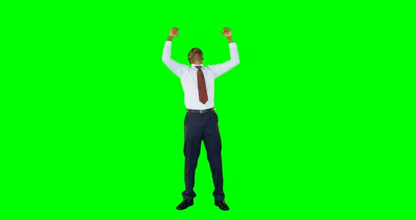 Excited businessman standing against green background