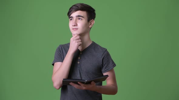 Young Handsome Iranian Teenage Boy Against Green Background