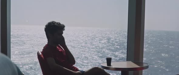 Man having a phone call sitting at the bar of a ferry