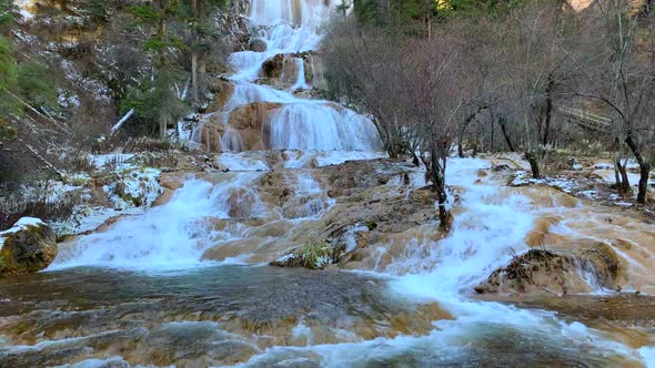 wide shots of big and small water fall streaming on the yellow stones